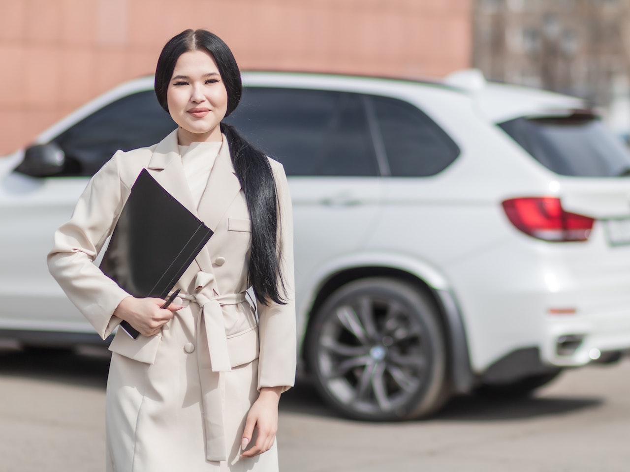 Woman in Car Insurance Company Holding Black Folder